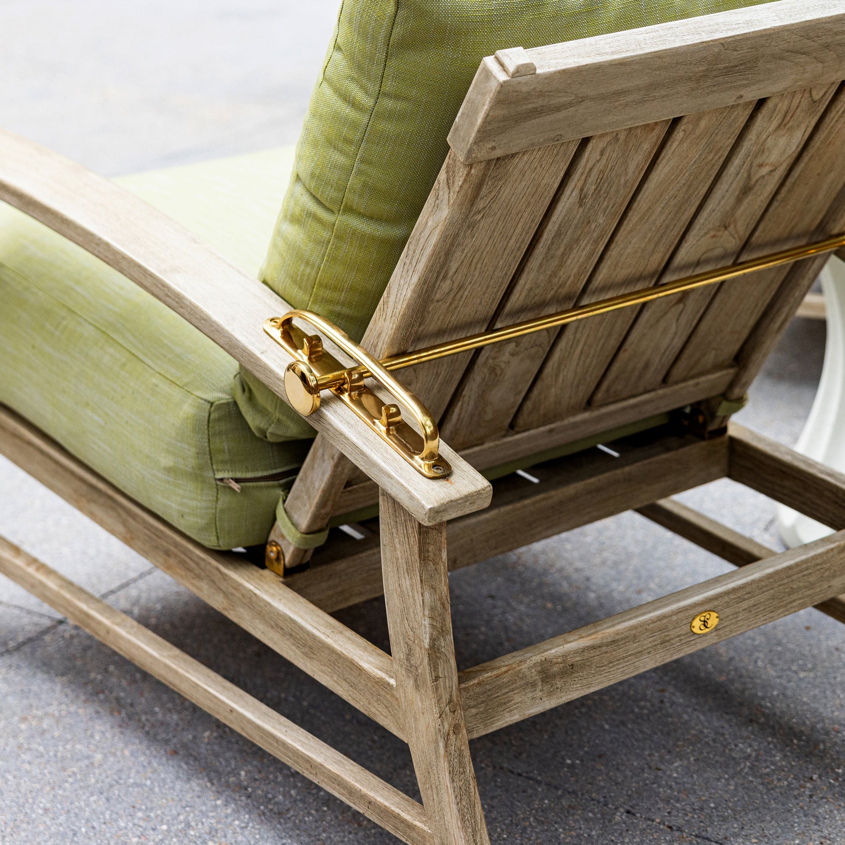 Wooden outdoor chair with green cushions on a patio