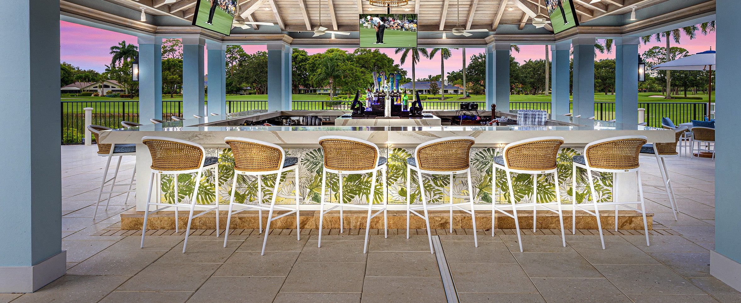 Outdoor bar area with chairs and a scenic view of a golf course.