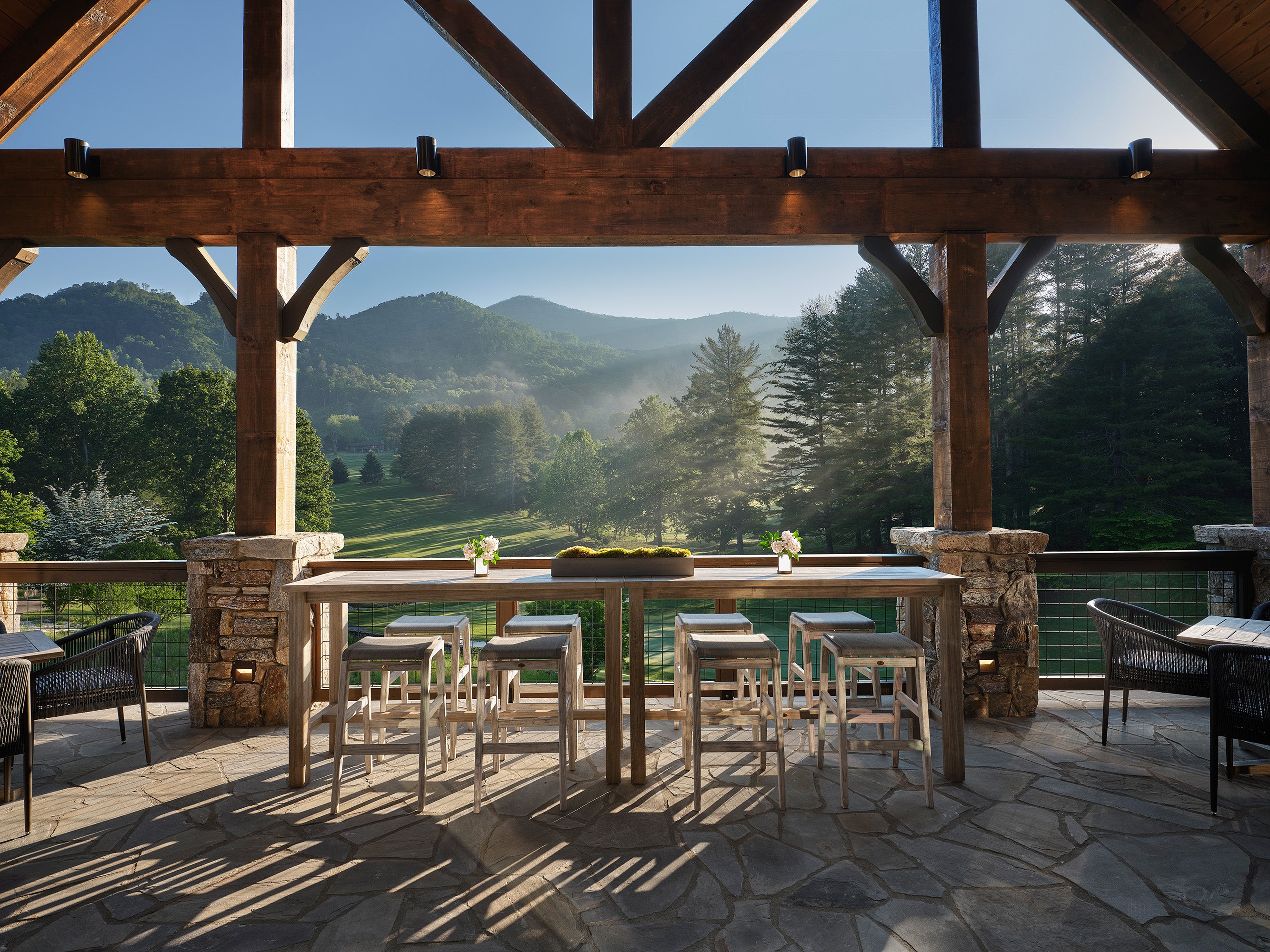 Outdoor dining area with wooden pergola and mountain view