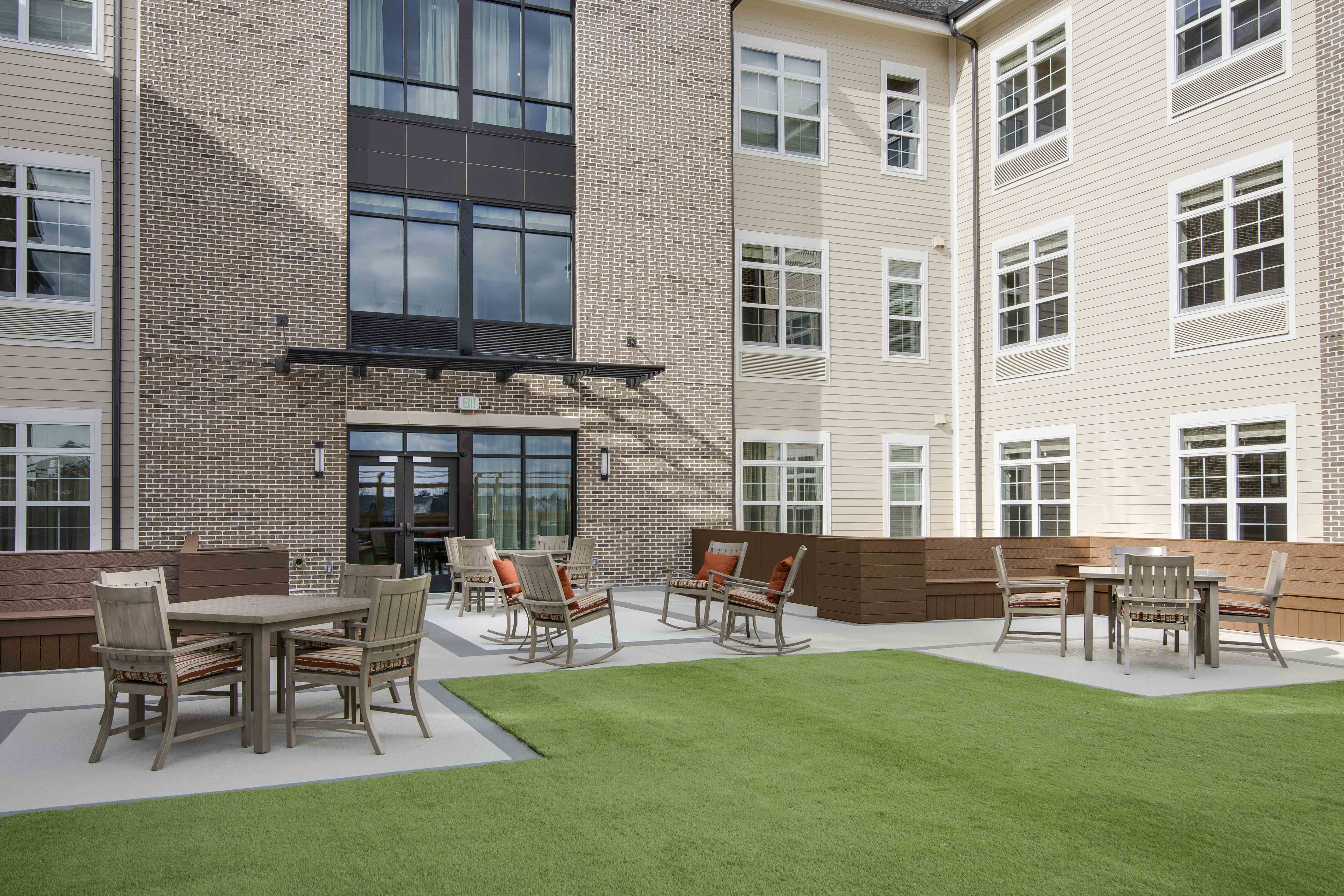 Outdoor seating area with tables and chairs in front of a building